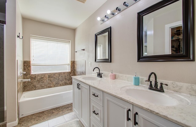 bathroom with a tub to relax in, tile patterned floors, and vanity
