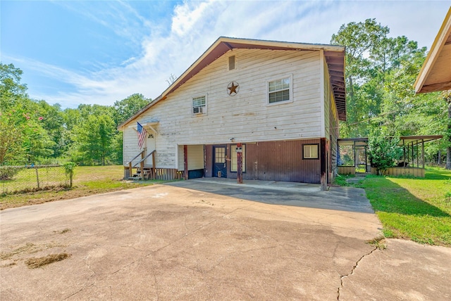 view of front of house with driveway, fence, and a front lawn