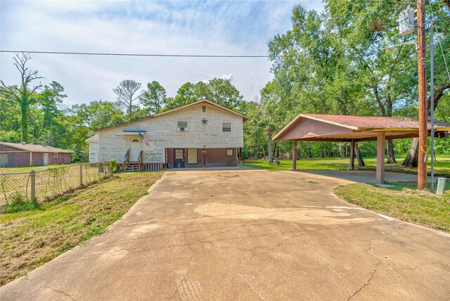 144DEERPATH Deer Path, Livingston, TX 77351 - view of front of property with concrete driveway, a detached carport, and fence