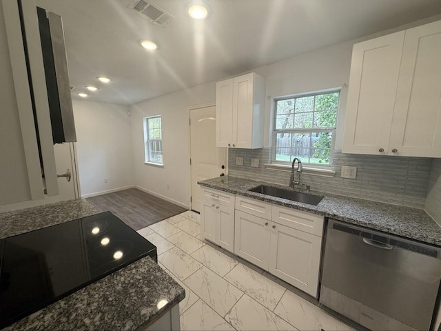 kitchen featuring tasteful backsplash, sink, dark stone countertops, white cabinets, and stainless steel dishwasher