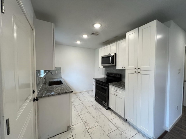 kitchen featuring sink, black / electric stove, white cabinets, dark stone counters, and backsplash