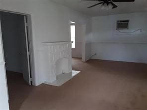 spare room featuring a ceiling fan and a wall unit AC