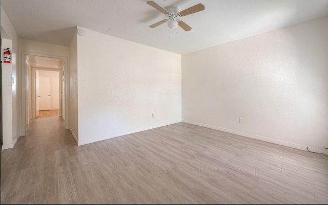 empty room with light hardwood / wood-style floors and ceiling fan