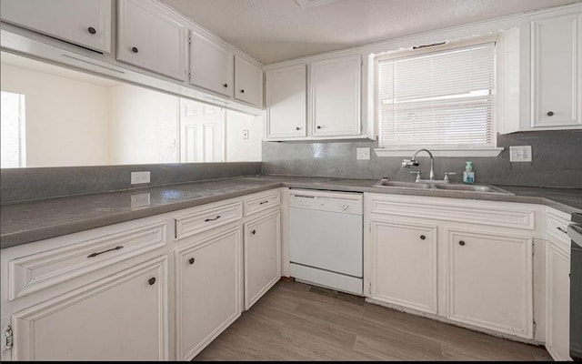 kitchen featuring sink, dishwasher, white cabinetry, decorative backsplash, and light wood-type flooring