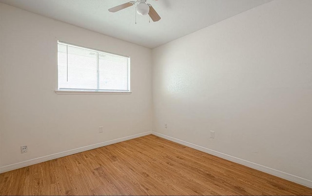 empty room with light wood finished floors, baseboards, and a ceiling fan