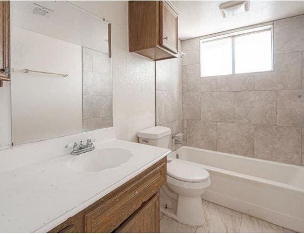 bathroom featuring tub / shower combination, vanity, and toilet