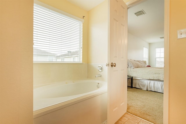 bathroom with tile patterned flooring and a bathtub