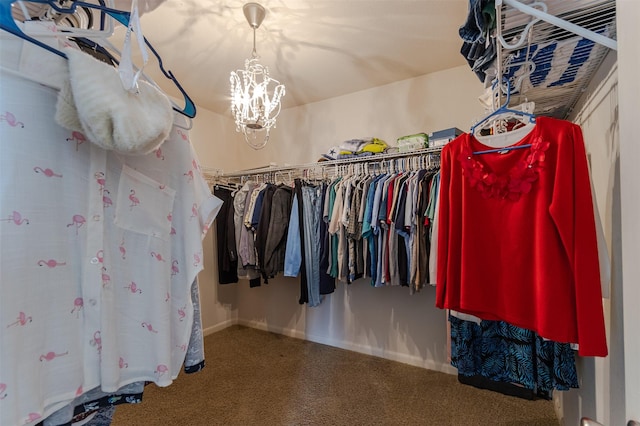 walk in closet featuring a notable chandelier and carpet