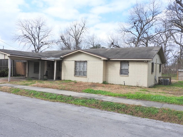 view of front facade with central AC unit and a carport