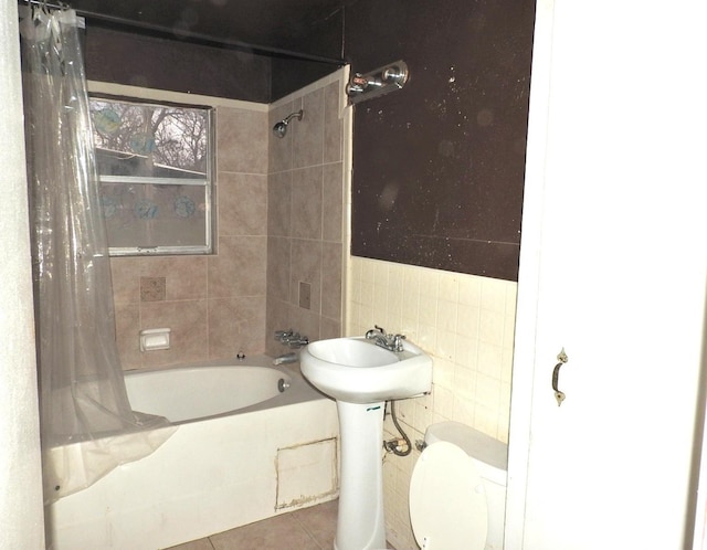 bathroom featuring shower / bath combination with curtain, tile patterned floors, toilet, and tile walls