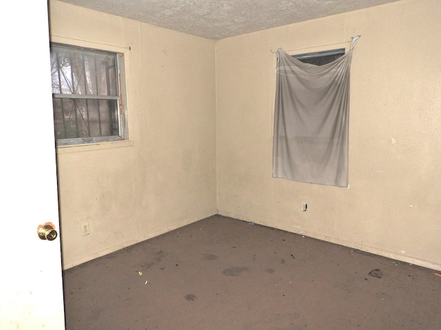 unfurnished room with concrete flooring and a textured ceiling