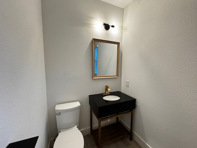 bathroom with hardwood / wood-style flooring, sink, and toilet