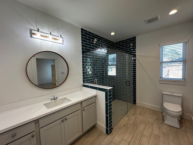 bathroom featuring vanity, an enclosed shower, and toilet