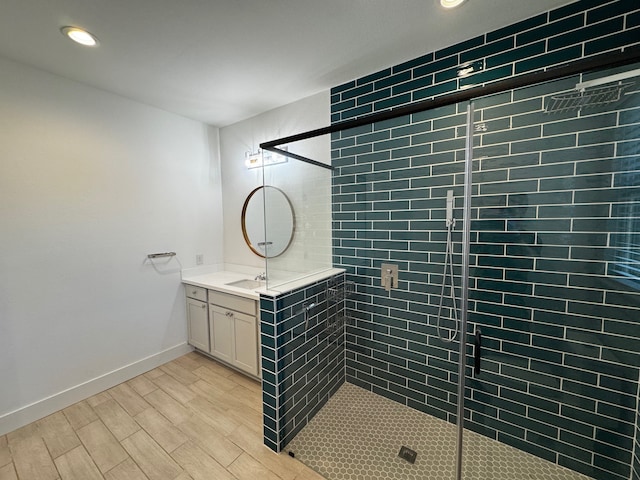 bathroom featuring hardwood / wood-style flooring, vanity, and a shower with door