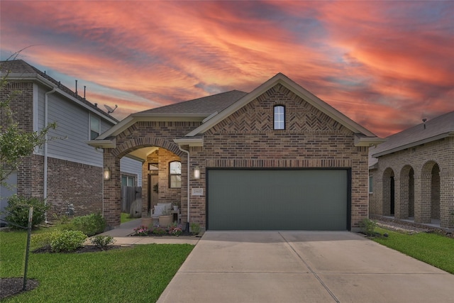 view of front of property with a garage and a lawn