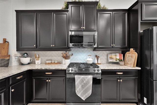 kitchen with stainless steel appliances, light stone countertops, and backsplash