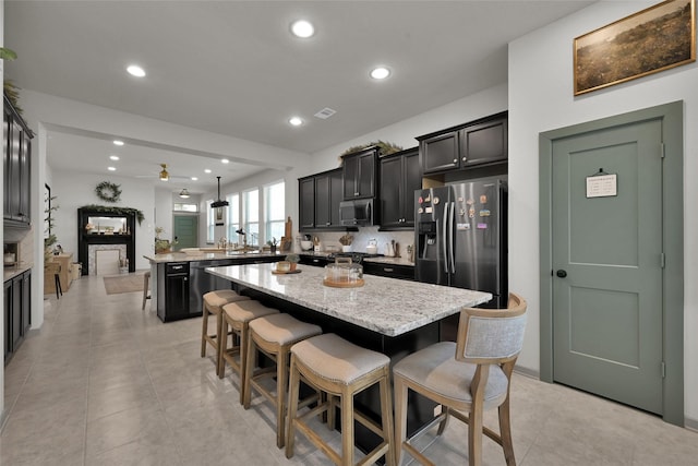 kitchen with stainless steel appliances, a center island, and a kitchen breakfast bar