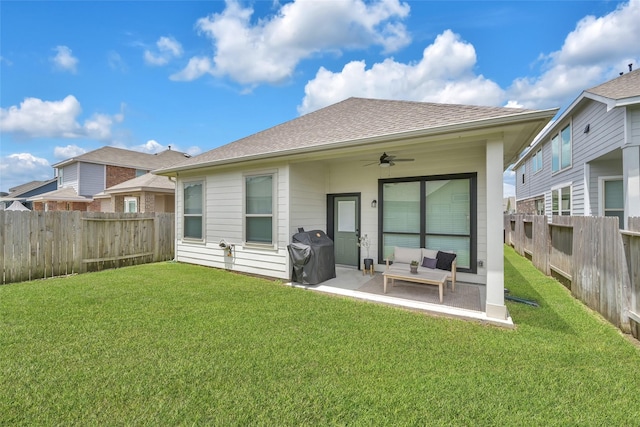 rear view of property featuring a patio area, outdoor lounge area, ceiling fan, and a lawn