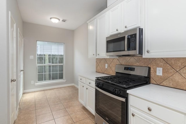 kitchen featuring white cabinetry, appliances with stainless steel finishes, tasteful backsplash, and light tile patterned floors