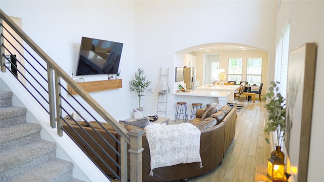 living room with a high ceiling and light hardwood / wood-style floors