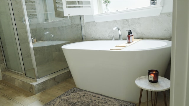 bathroom featuring separate shower and tub and backsplash