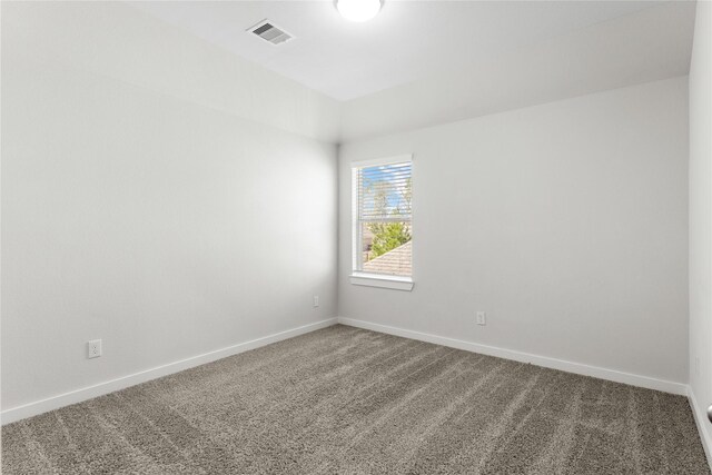 carpeted spare room featuring visible vents and baseboards