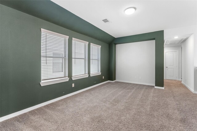 spare room with baseboards, carpet floors, lofted ceiling, and visible vents