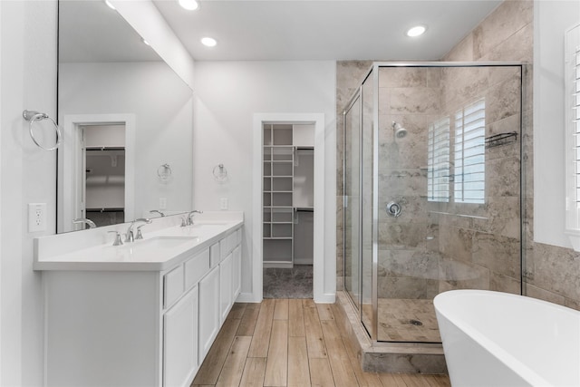 bathroom featuring a soaking tub, a stall shower, and a sink