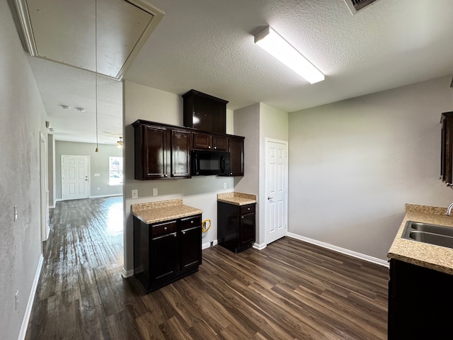 kitchen featuring dark brown cabinetry, sink, dark hardwood / wood-style floors, and a textured ceiling