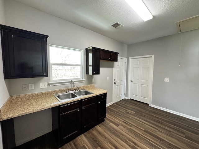 kitchen featuring dark hardwood / wood-style flooring, sink, dark brown cabinets, and a textured ceiling