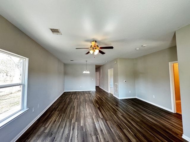 unfurnished living room with dark hardwood / wood-style floors and ceiling fan with notable chandelier