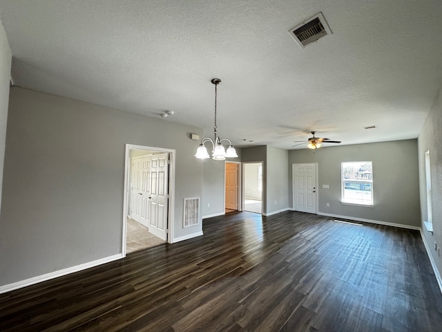 interior space featuring dark hardwood / wood-style floors, ceiling fan with notable chandelier, and a textured ceiling