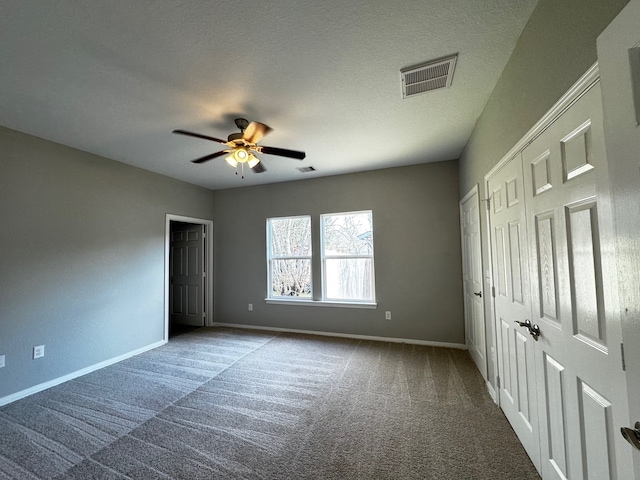 unfurnished bedroom featuring ceiling fan, carpet floors, and a textured ceiling