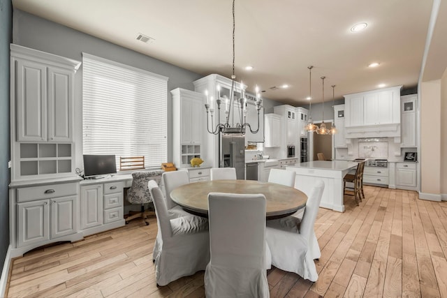 dining room featuring built in desk, recessed lighting, visible vents, and light wood-style floors