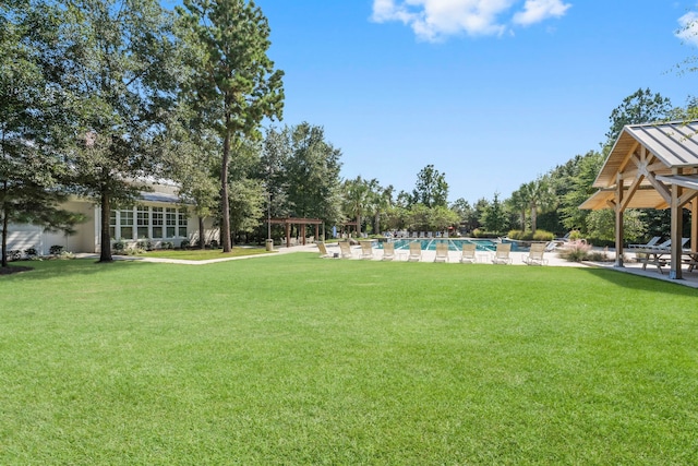 view of yard featuring a patio, a gazebo, a community pool, and a pergola