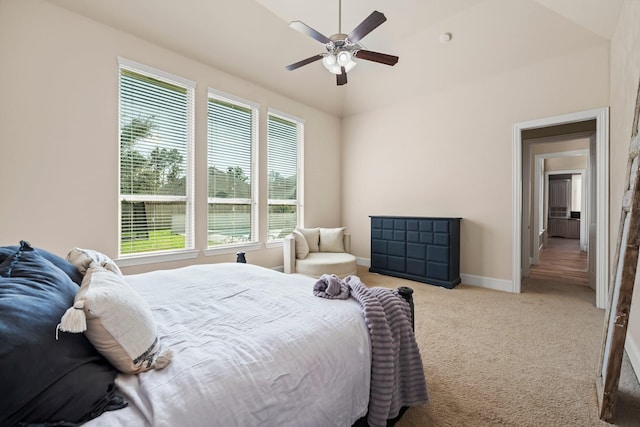 carpeted bedroom with ceiling fan, baseboards, and vaulted ceiling