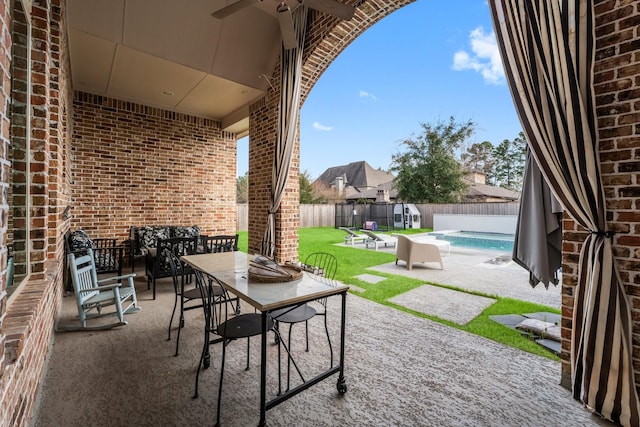 view of patio featuring outdoor dining space, a fenced backyard, and a fenced in pool