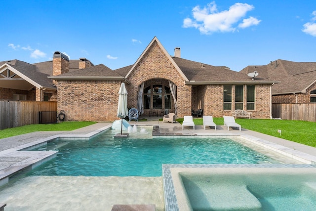 view of swimming pool with a pool with connected hot tub, a lawn, a fenced backyard, and a patio