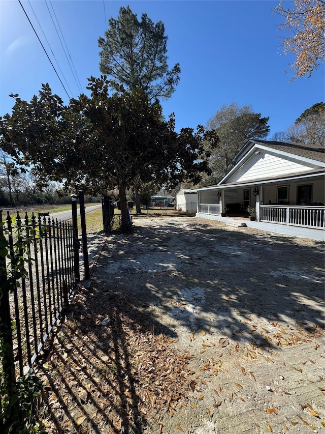 view of side of property featuring a porch and fence