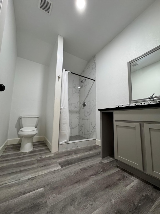 full bath featuring a shower with curtain, wood finished floors, visible vents, baseboards, and toilet