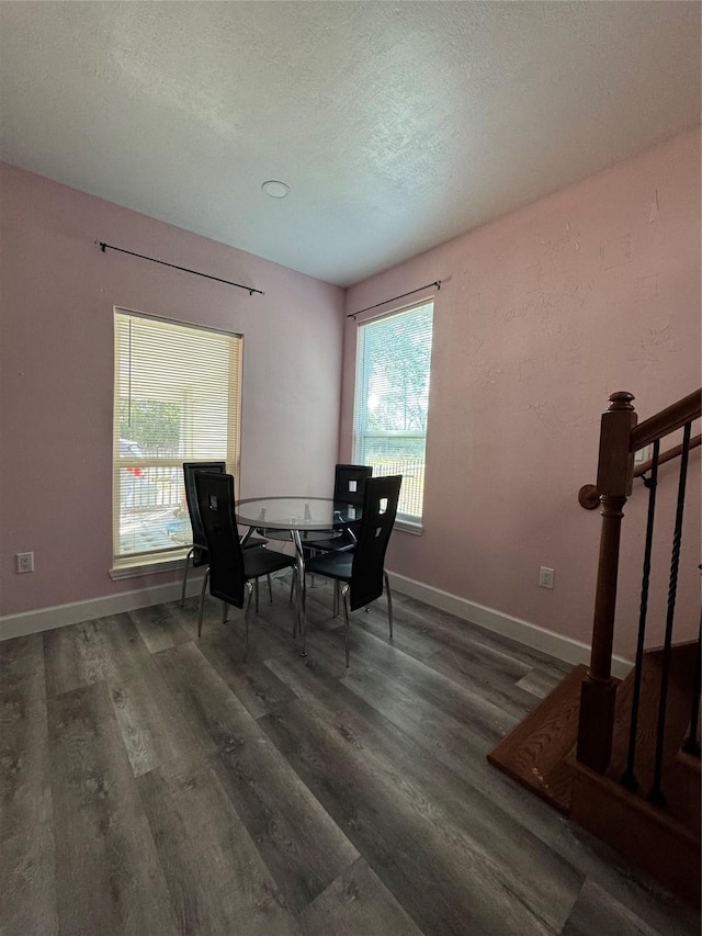 dining room with stairway, a textured ceiling, baseboards, and wood finished floors