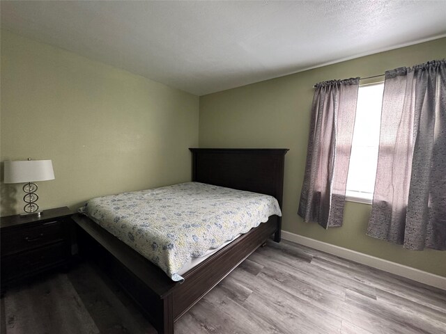 bedroom featuring baseboards and wood finished floors