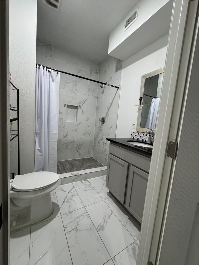 full bathroom featuring vanity, visible vents, a shower stall, toilet, and marble finish floor