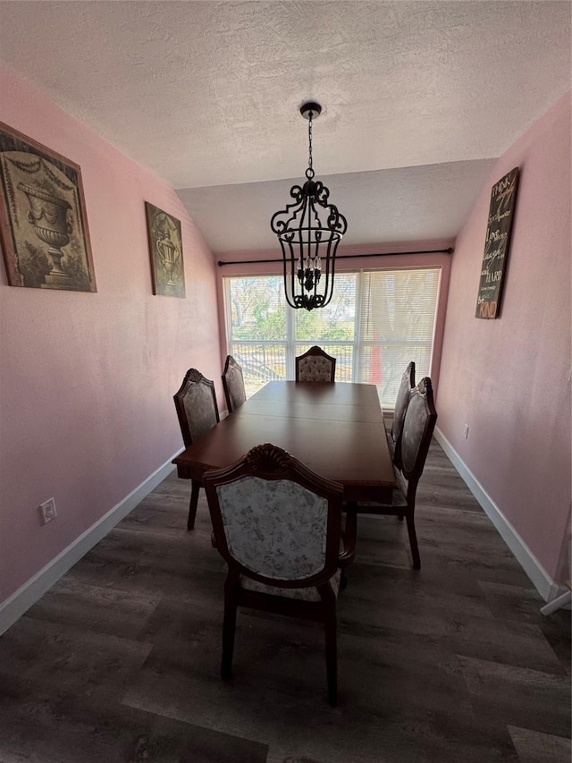 dining room with dark hardwood / wood-style flooring, lofted ceiling, a chandelier, and a textured ceiling