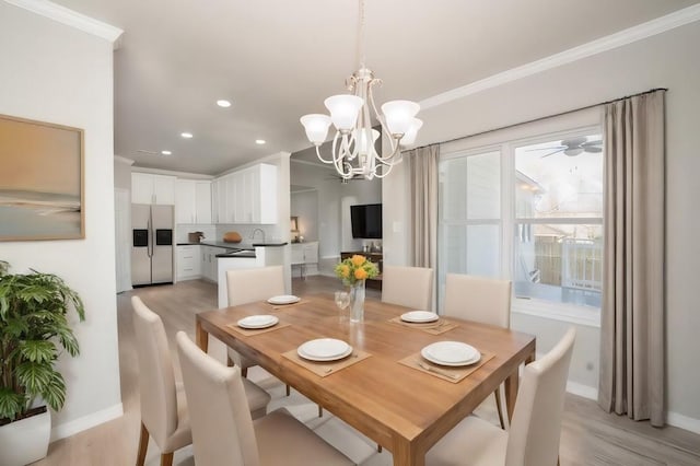 dining space with light hardwood / wood-style floors, ornamental molding, a chandelier, and sink