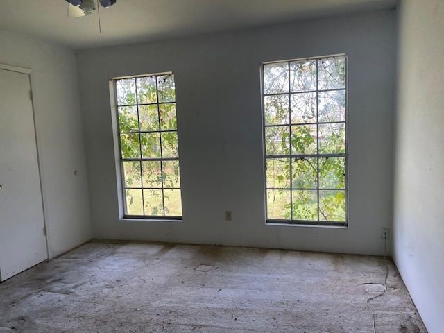 unfurnished room featuring ceiling fan and a healthy amount of sunlight