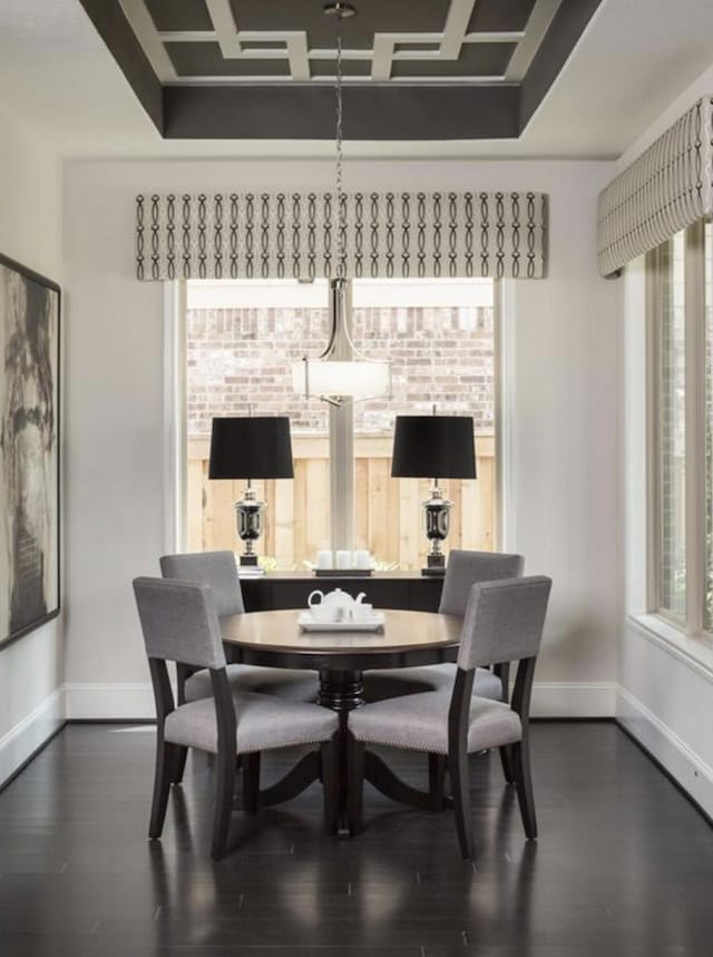 dining room with coffered ceiling and dark hardwood / wood-style flooring