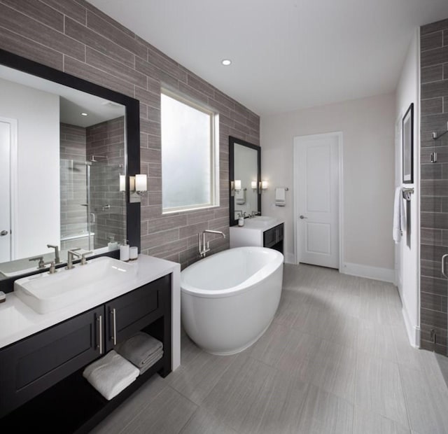 bathroom featuring shower with separate bathtub, tile walls, and vanity