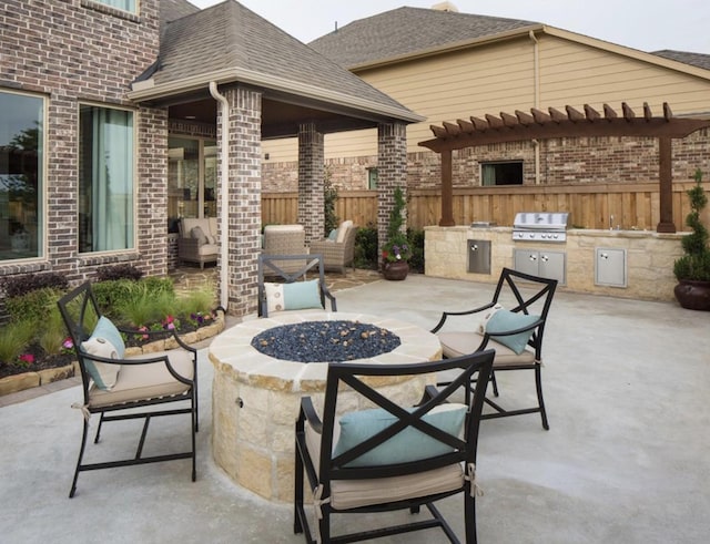 view of patio / terrace featuring an outdoor kitchen, area for grilling, and a fire pit