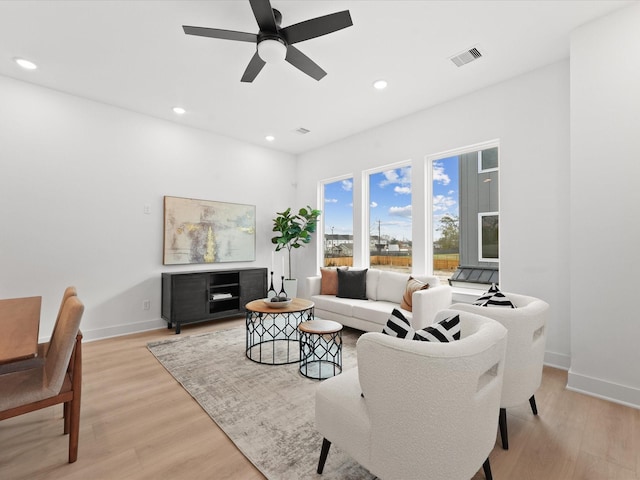 living room with light hardwood / wood-style flooring and ceiling fan